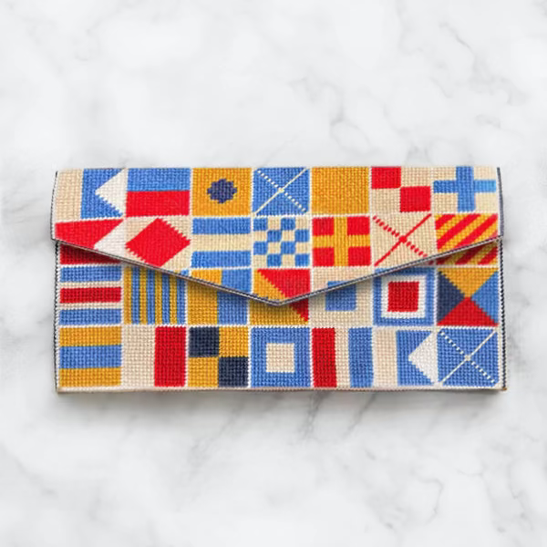 Colorful geometric patterned clutch bag on a white marble surface