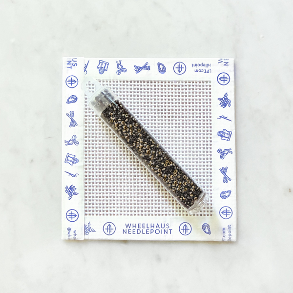 Needlepoint beads on a white background with a branded mat
